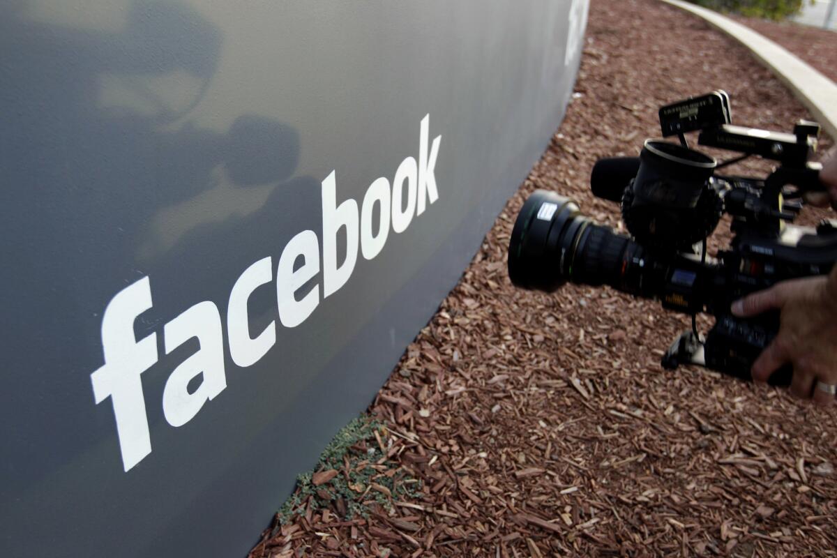 En esta imagen de archivo, tomada el 18 de mayo de 2012, un cámara de televisión graba el logo de Facebook en el exterior de su sede en Menlo Park, California. (AP Foto/Paul Sakuma, archivo)