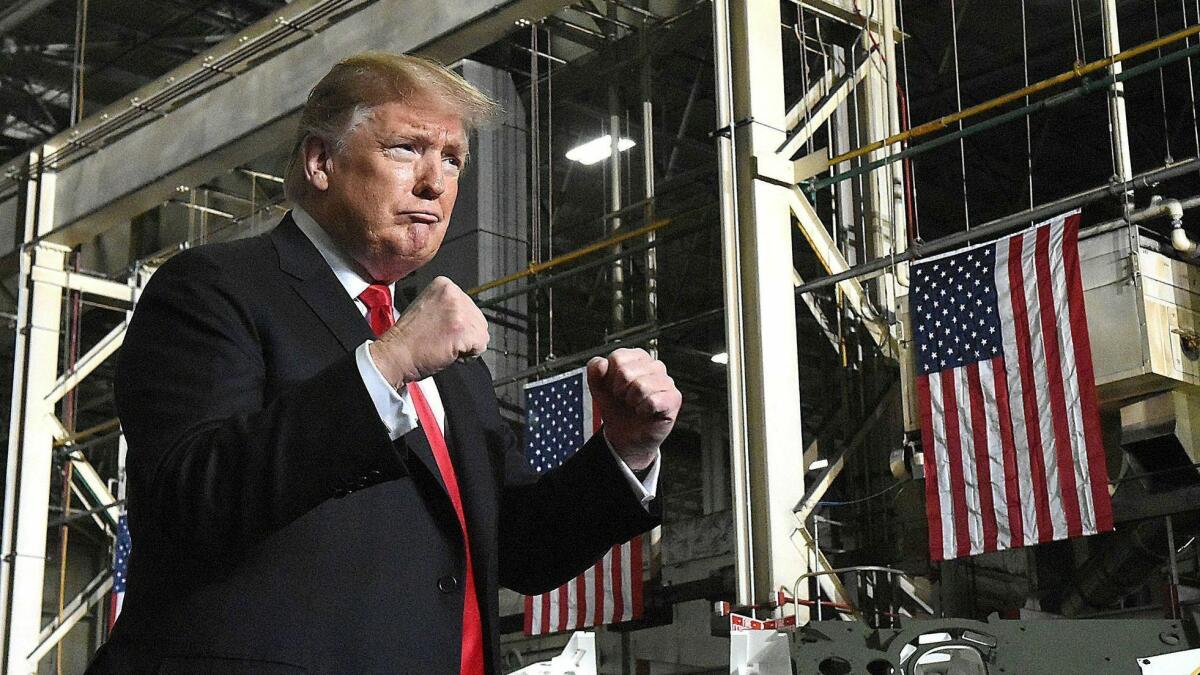 President Trump make two fists while making his entrance to the Joint Systems Manufacturing Center.