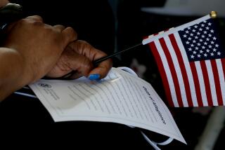 LOS ANGELES, CA - JULY 01:. An immigrant holds a flag and the Oath of Allegiance during a U.S. citizenship ceremony for naturalized citizens aboard the battleship USS Iowa in the Port of Los Angeles on Thursday, July 1, 2021. The event newly minted American citizens from Asia, Africa, Europe and the Americas. (Luis Sinco / Los Angeles Times)