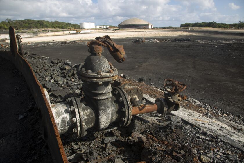 Restos carbonizados de tanques de petróleo están a la vista en la Base de Supertanques en Matanzas, Cuba, el viernes 9 de diciembre de 2022. Un rayo prendió un incendio el 5 de agosto en la base y mató a 16 personas, dejó más de 100 heridos y destruyó cuatro de los tanques de la instalación. (AP Foto/Ismael Francisco)
