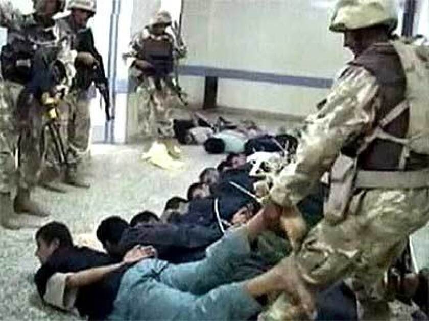 TV footage shows a soldier dragging an Iraqi detainee after coalition forces captured a hospital in Fallouja. As many as 5,000 insurgents are estimated to be in the town.