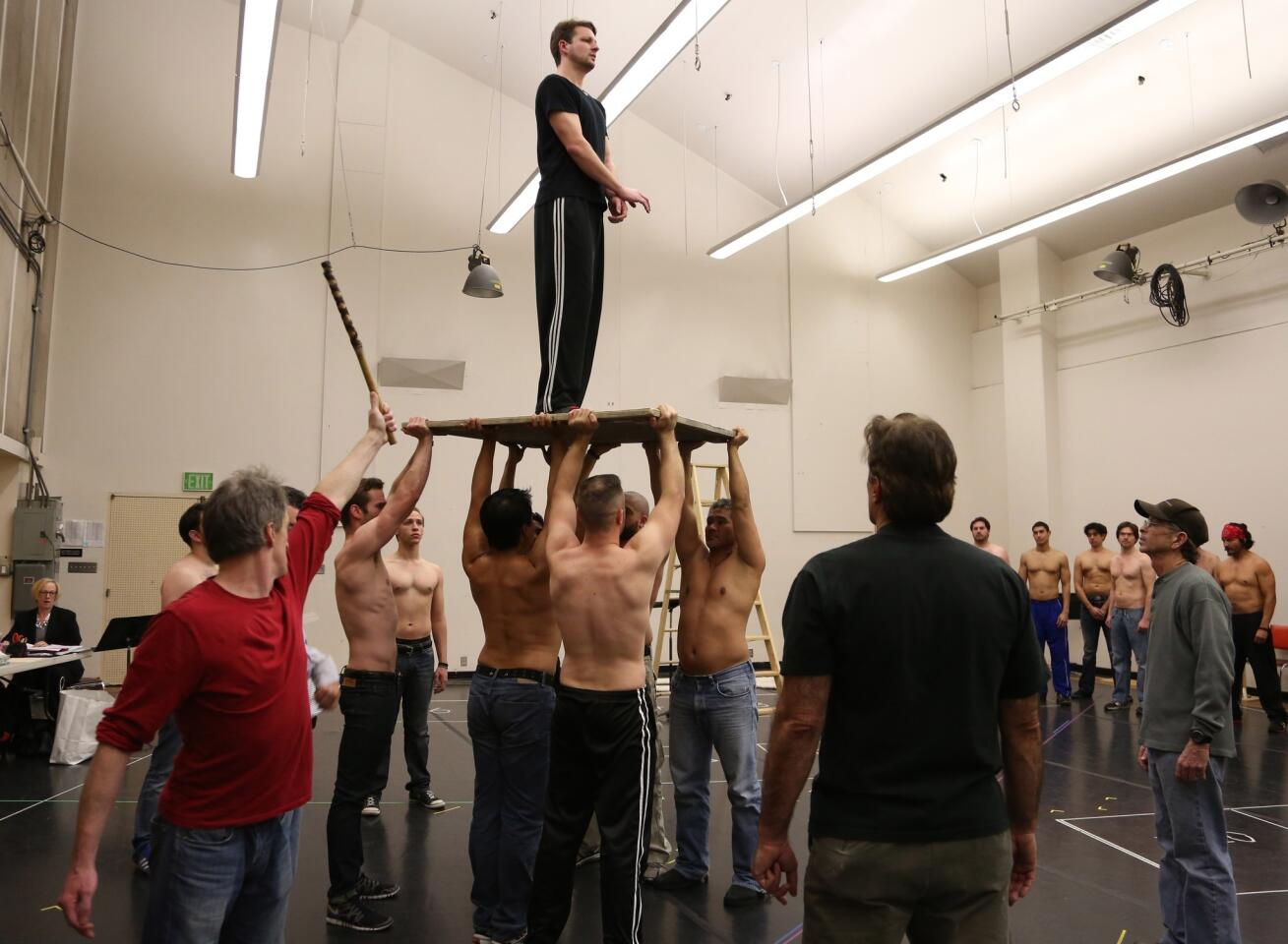Actors practice lifting Liam Bonner, who plays the title role, during a rehearsal of Los Angeles Opera's "Billy Budd" at the Dorothy Chandler Pavilion in Los Angeles.