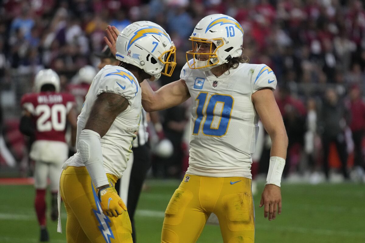 Los Angeles Chargers quarterback Justin Herbert (10) and tight end Gerald Everett (7) celebrate their game-winning two-point conversion against the Arizona Cardinals during the second half of an NFL football game, Sunday, Nov. 27, 2022, in Glendale, Ariz. The Chargers defeated the Cardinals 25-24. (AP Photo/Rick Scuteri)