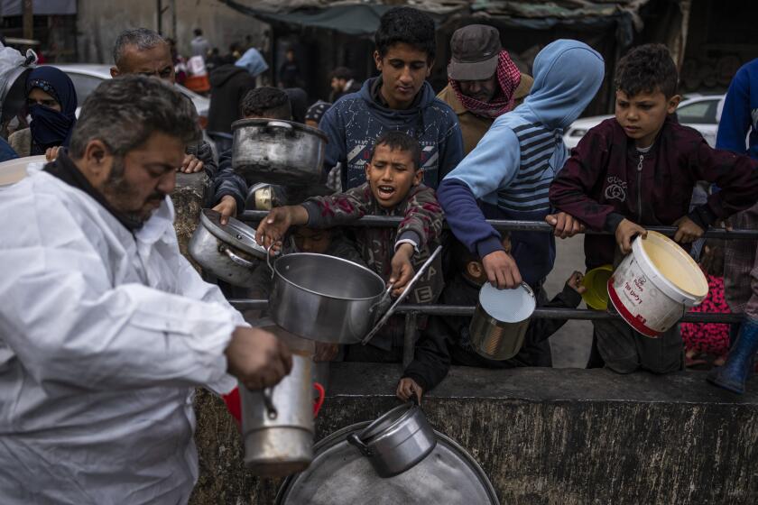 Palestinians line up for free food in Rafah, Gaza Strip, Friday, Feb. 23, 2024. An estimated 1.5 million Palestinians displaced by the war took refuge in Rafahor, which is likely Israel's next focus in its war against Hamas.(AP Photo/Fatima Shbair)