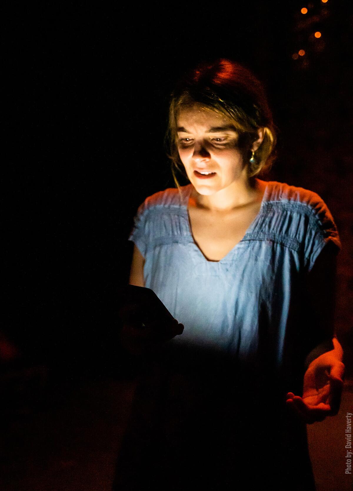 A woman with her face illuminated by the light from a computer screen