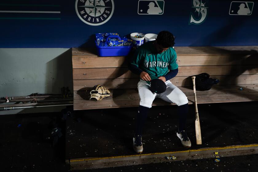Seattle Mariners' Josh Rojas sits in the dugout after striking out for the final out in a 6-1 loss to the Texas Rangers, who clinched a playoff spot in the American League, in a baseball game, Saturday, Sept. 30, 2023, in Seattle. (AP Photo/Lindsey Wasson)
