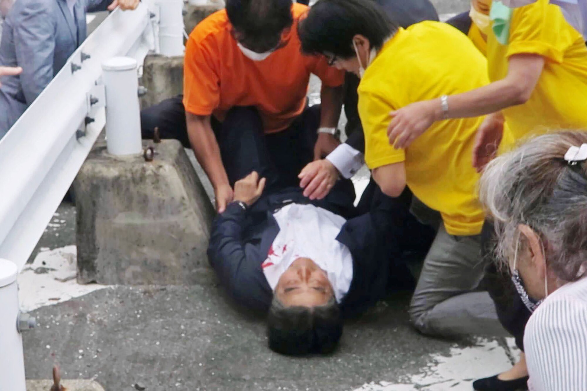 Japan’s former Prime Minister Shinzo Abe is attended on the ground after being shot Friday