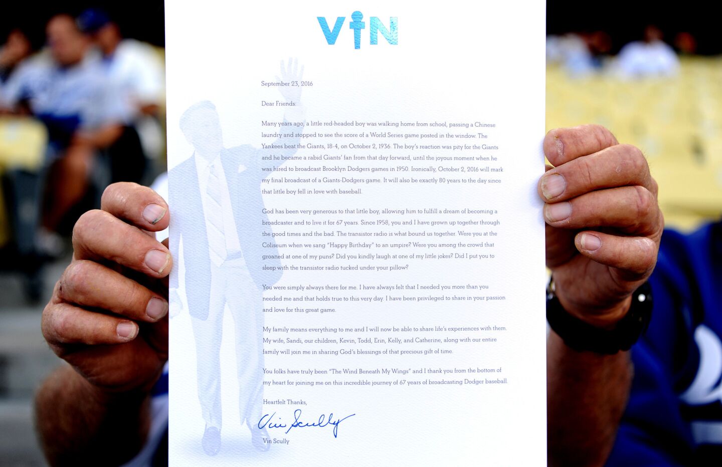A fan holds a letter from Vin Scully that was given out before the Dodgers game on Friday night.