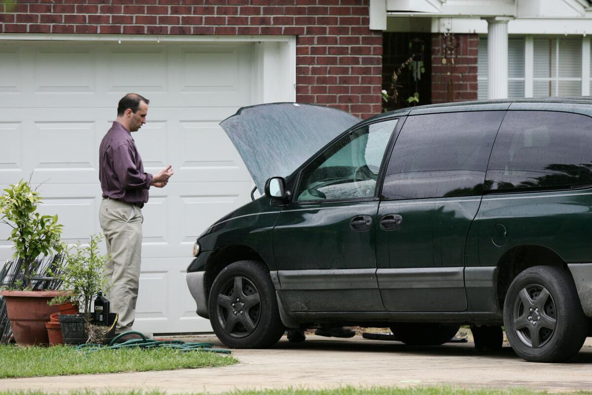 James Everett Dutschke works on his mini-van in his driveway in Tupelo, Miss., on Friday. Hours later, Dutschke was arrested in connection with poison letters sent to President Obama and others.