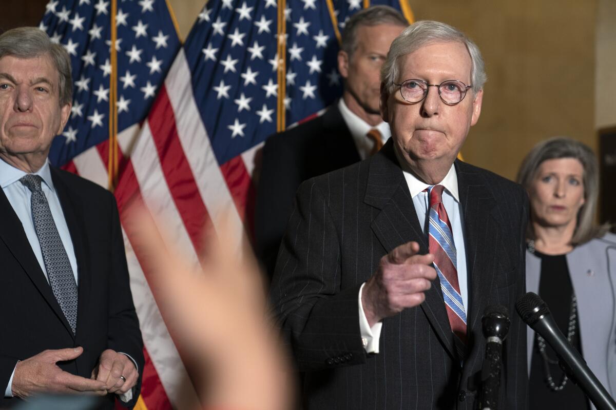 Senate Minority Leader Mitch McConnell listens as he speaks to reporters on Capitol Hill in Washington.