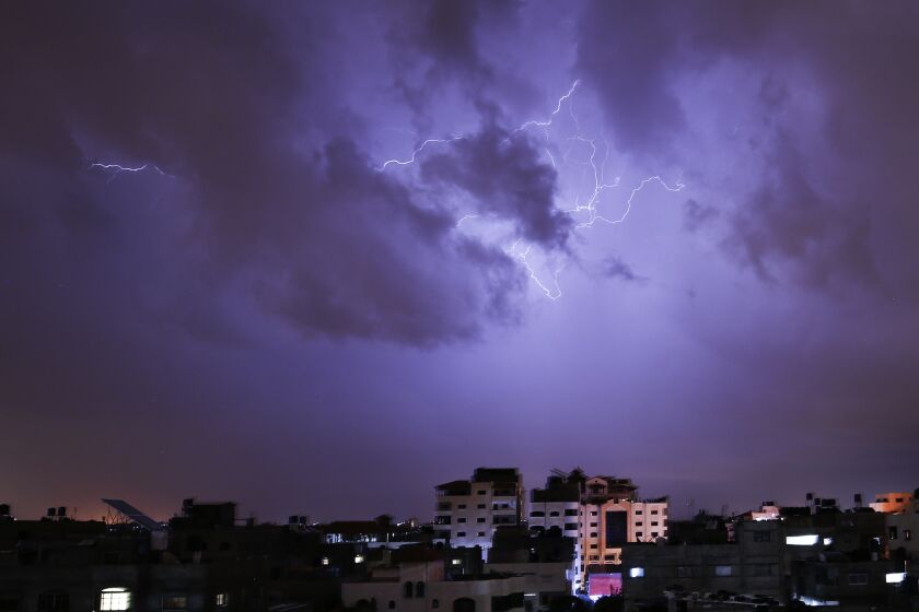 Lightning flash over buildings during a thunderstorm in Gaza city on November 26, 2020. (Photo by MOHAMMED ABED / AFP) (Photo by MOHAMMED ABED/AFP via Getty Images)