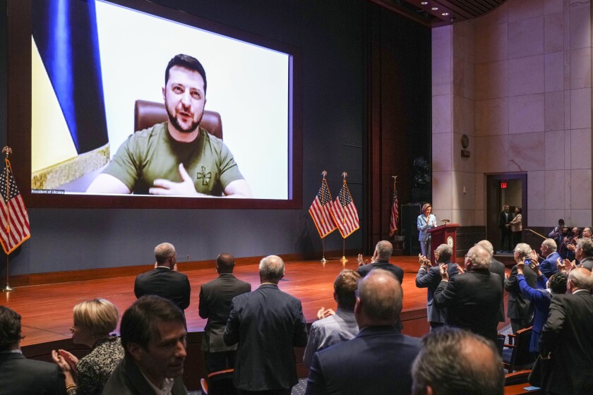 Ukraine President Volodymyr Zelensky appears on a screen before lawmakers.