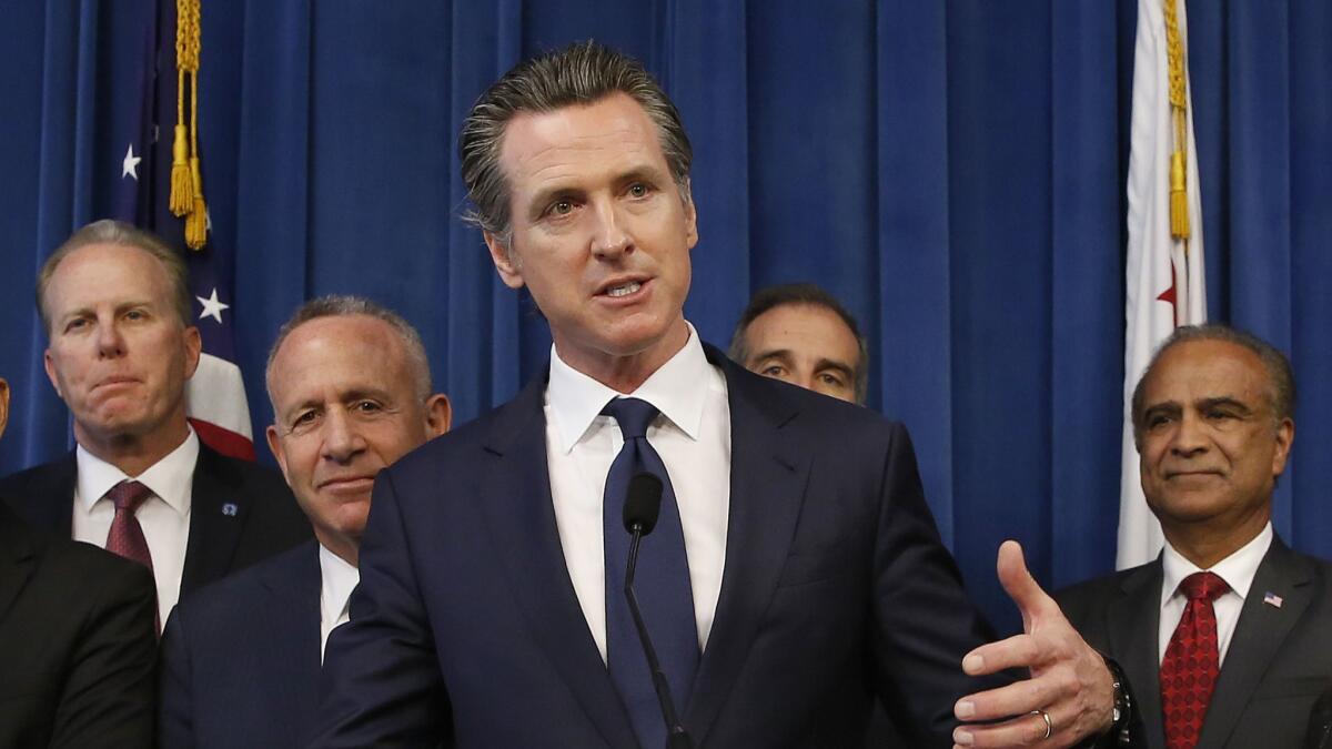 Gov. Gavin Newsom, center, discusses the homeless problem facing California after a meeting in Sacramento in March with the mayors of some of the state's largest cities.