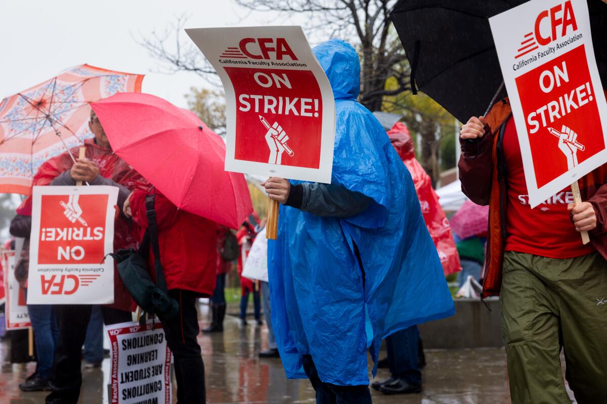 People hold signs on a picket line 