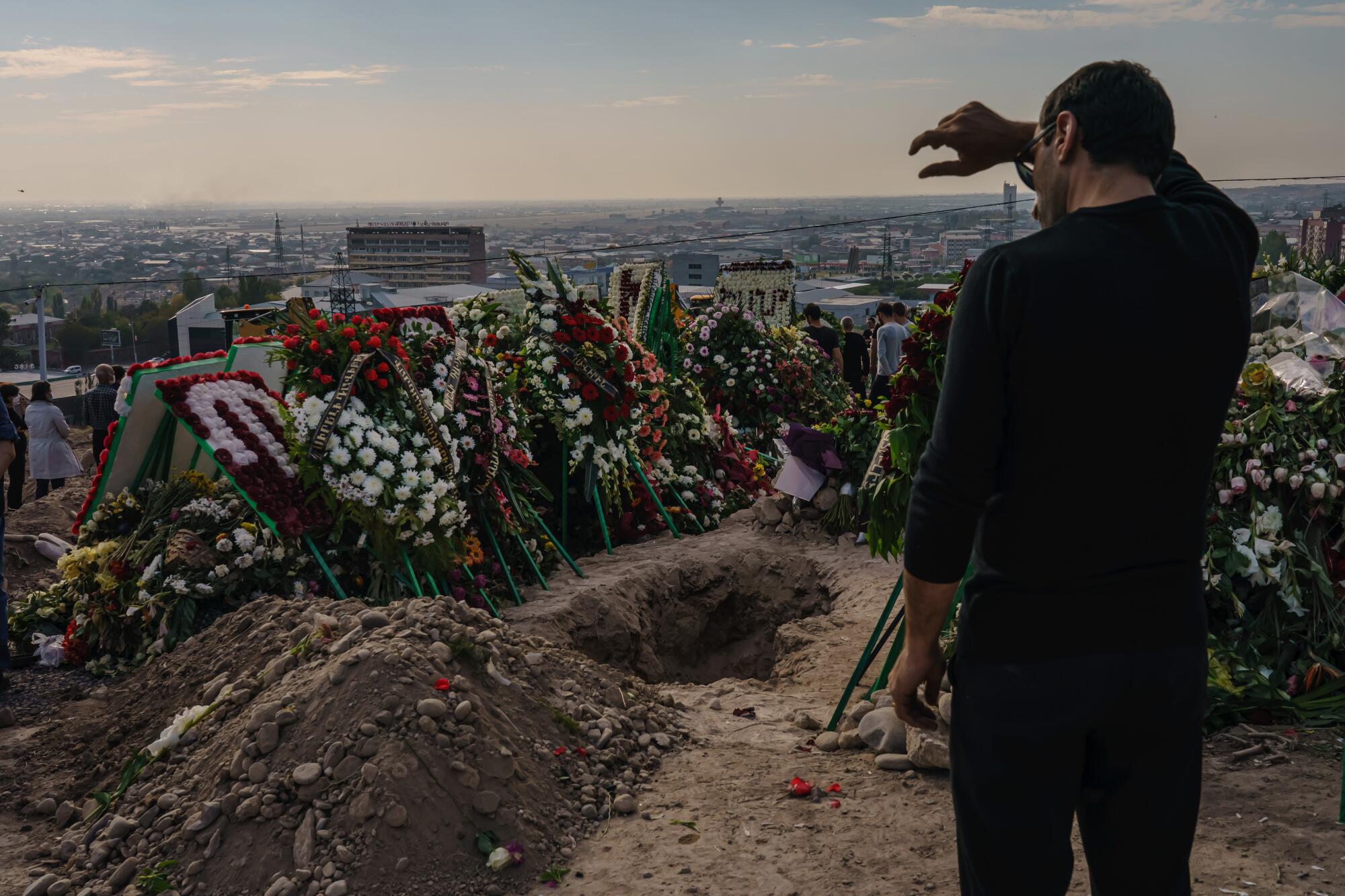 A man stares at an empty grave awaiting a casket at Yerablur Military Memorial Cemetery.