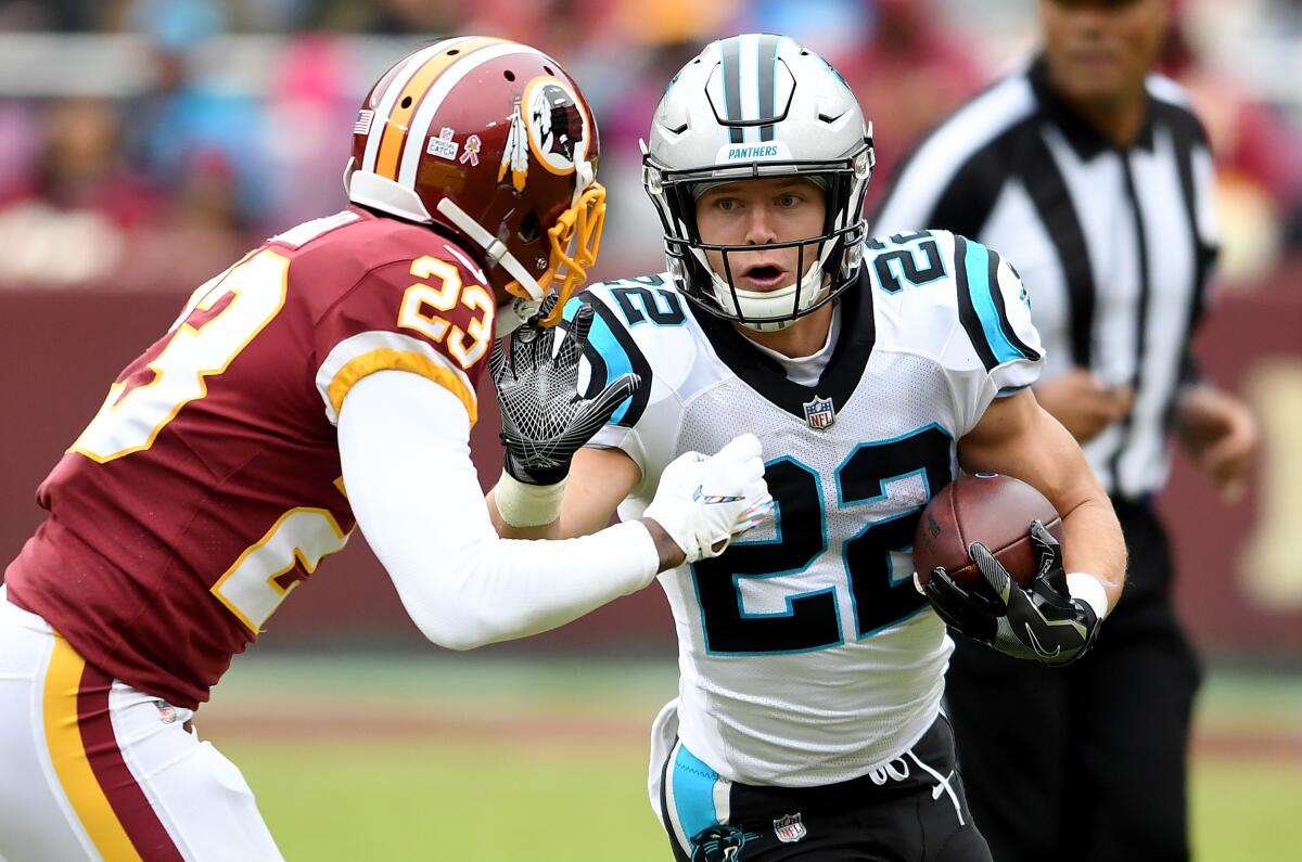 Carolina Panthers running back Christian McCaffrey tries to fend off Washington's Quinton Dunbar during a game in October 2018.