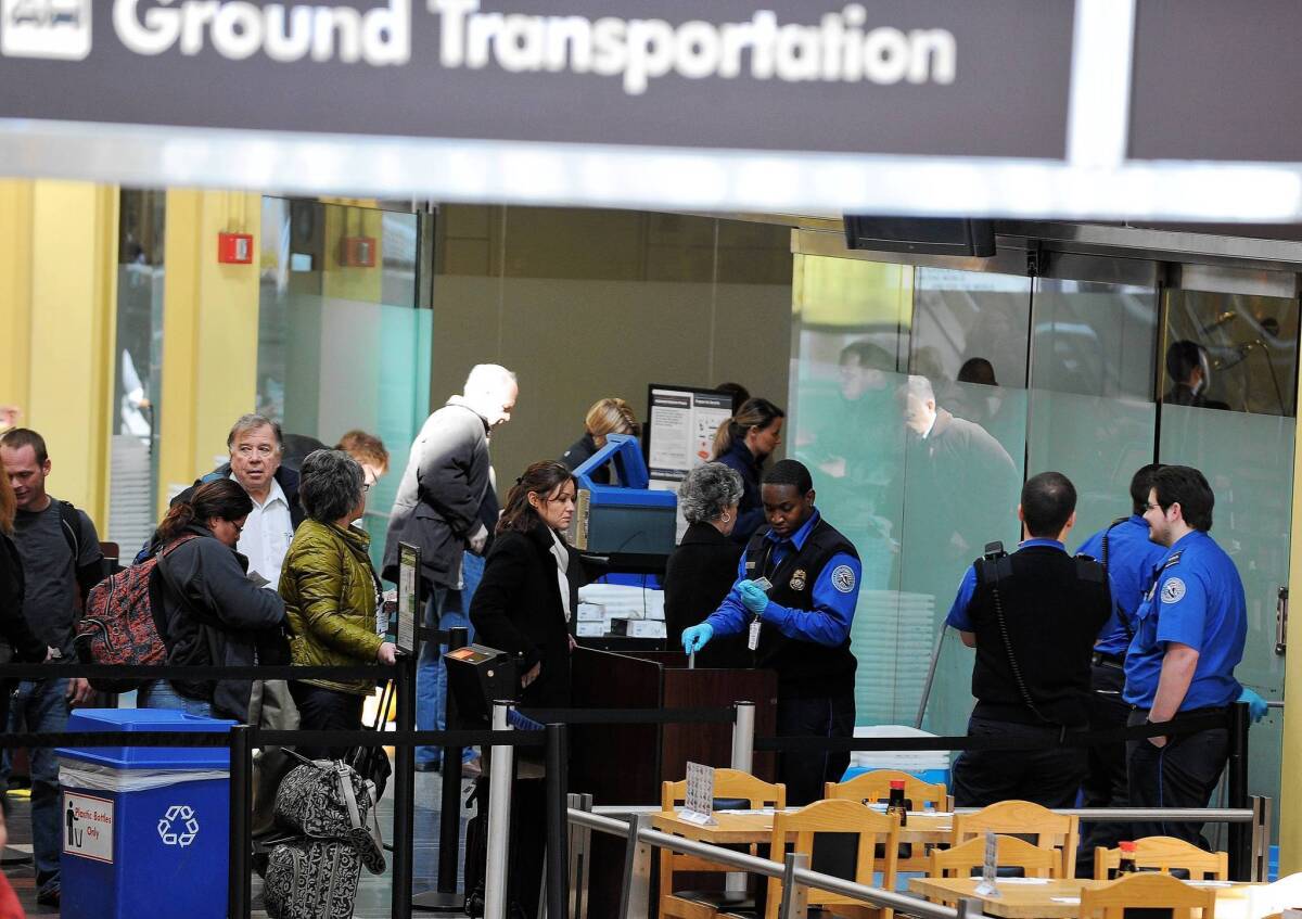 TSA personnel screen passengers at Ronald Reagan Washington National Airport. The agency has announced that it is easing screening for wounded soldiers and veterans.