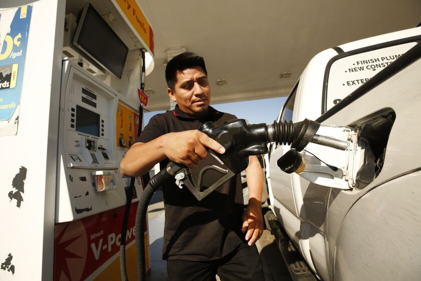 LOS ANGELES, CA - NOVEMBER 15: Alex Reyes, 28, began filling his work truck and stoped when he noticed the prices on the large marquee as drivers select from various fuels priced near of above over $6 dollars at a Shell gas station located at South Fairfax, West Olympic and San Vicente Blvd in Los Angeles as California gas prices hit an average price of $4.676 Sunday, setting the highest recorded average price for regular gasoline, according to AAA. America's largest state by population has the highest gas prices in the country. The national average dropped slightly to $3.413 Sunday. Carthay Circle on Monday, Nov. 15, 2021 in Los Angeles, CA. (Al Seib / Los Angeles Times).