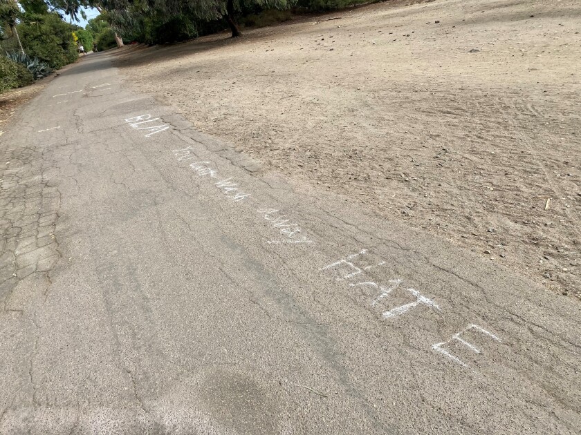"BLM" and "You can’t wash away hate" are pictured written in chalk on the La Jolla Bike Path on Sept. 21.