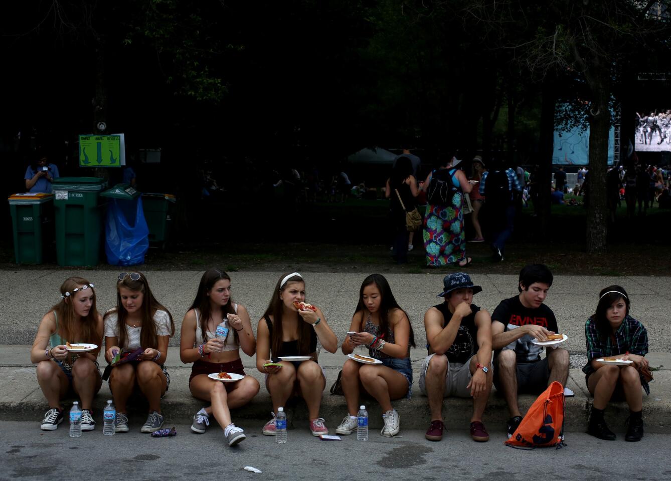 A group of festival goers enjoy Lou Malnati's pizza during the first day of Lollapalooza in Grant Park.