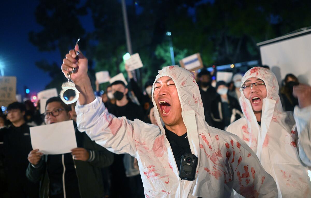 Lijian Jie yells in protest during a candlelight vigil for victims who suffer under China’s stringent lockdown.