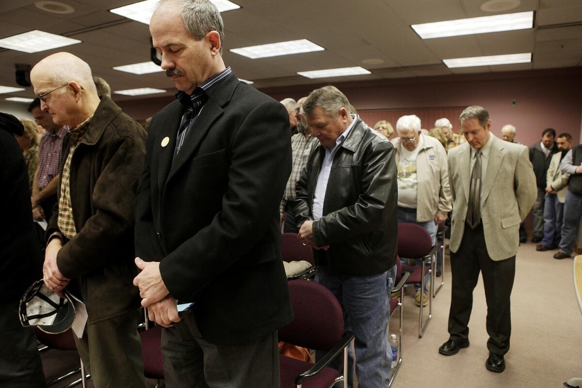 At a meeting of the Rapid City Council this month, attendees bow their heads in prayer.
