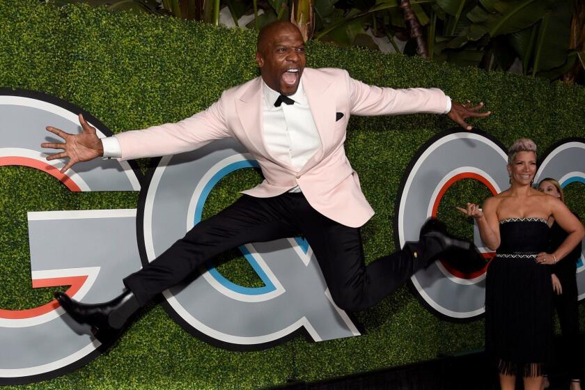 Terry Crews jumps as Rebecca King-Crews watches at the GQ Men of the Year Party at Chateau Marmont on Thursday, Dec. 7, 2017, in Los Angeles. (Photo by Chris Pizzello/Invision/AP)
