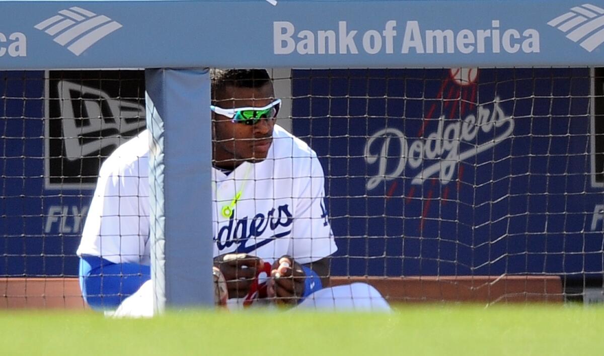 Dodgers outfielder Yasiel Puig watches from the dugout during the team's 8-4 home-opening loss to the Giants in 2014.