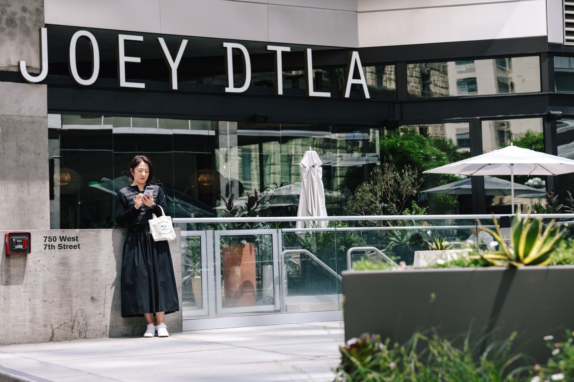 A woman stands outside Joey DTLA restaurant in downtown's financial district.