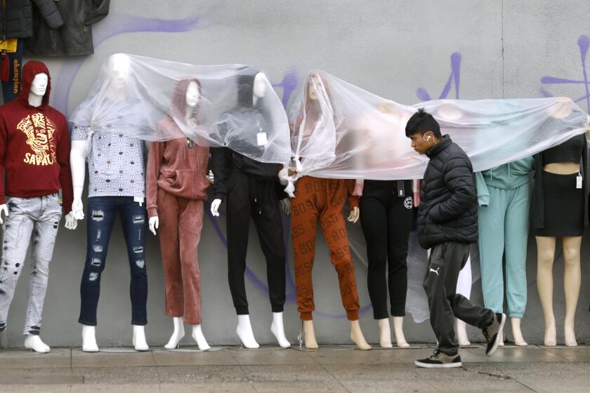 Los Angeles, California-Jan. 3, 2023-Mannequins are covered in plastic along W 8th St. in central Los Angeles as a light mist of rain falls on Jan. 3, 2023. Rain is expected for the the first week of January, with light mist filing in Los Angeles on Jan. 3, 2022. (Carolyn Cole / Los Angeles Times)
