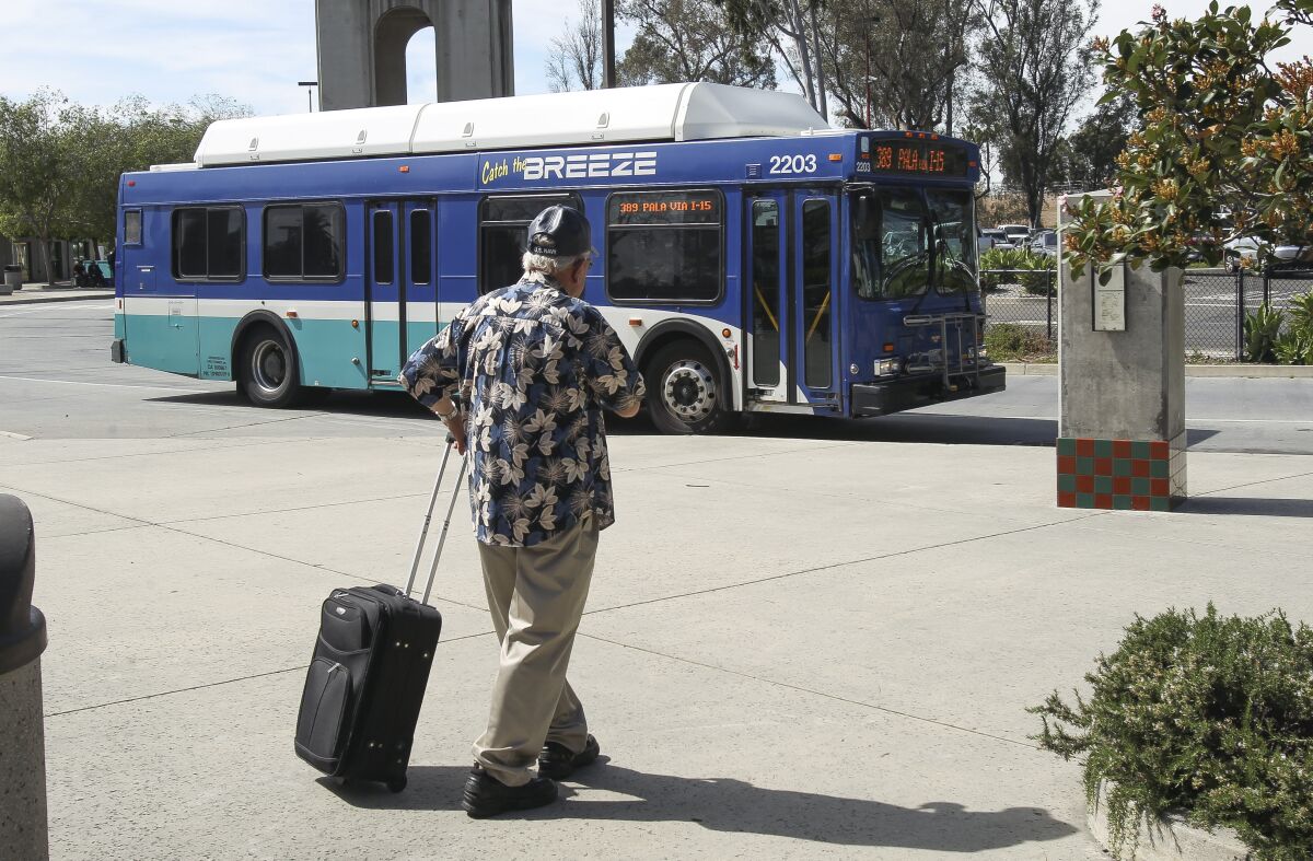 A man watches as a Breeze bus arrives at the Escondido Transit Center in Escondido in 2016.
