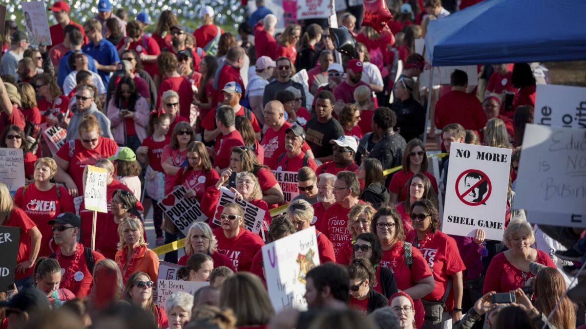 Teachers from across Kentucky gather on Friday outside the state Capitol to rally for increased funding and to protest changes to their state-funded pension system.