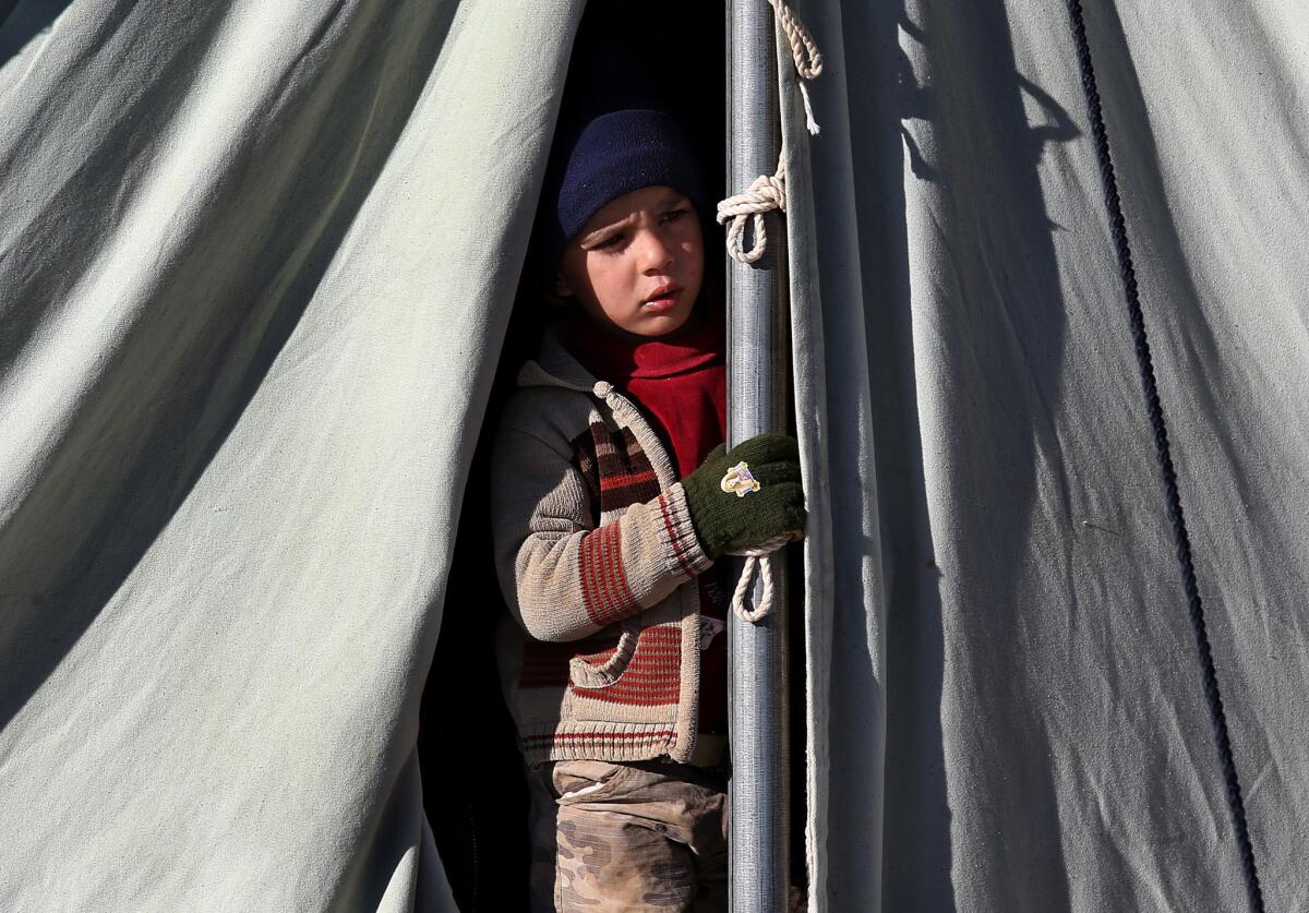 A Syrian child looks out from his tent at a refugee camp in the eastern Lebanese border town of Arsal on Friday.