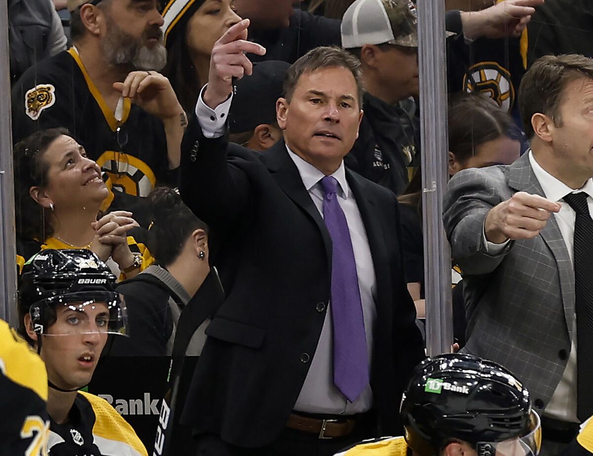 FILE -Boston Bruins head coach Bruce Cassidy, center, gestures during the third period of an NHL hockey game against the Pittsburgh Penguins, April 16, 2022, in Boston. The Bruins have fired Cassidy several weeks after losing in the first round of the playoffs. (AP Photo/Winslow Townson, File)