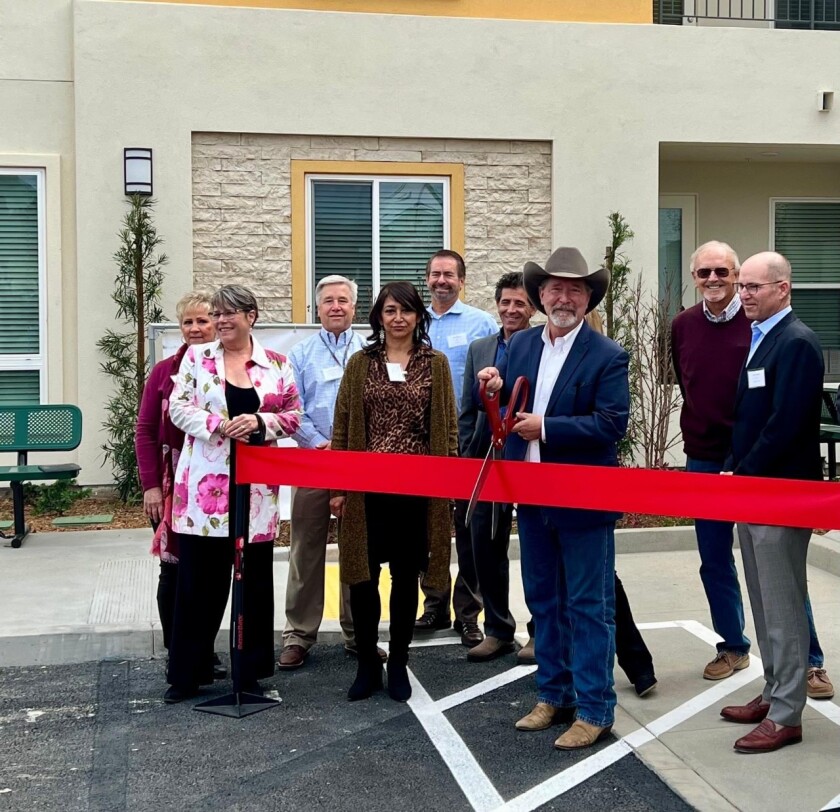 Poway Mayor Steve Vaus cuts the ceremonial ribbon for the Apollo low-income senior apartments at the Poway Commons.