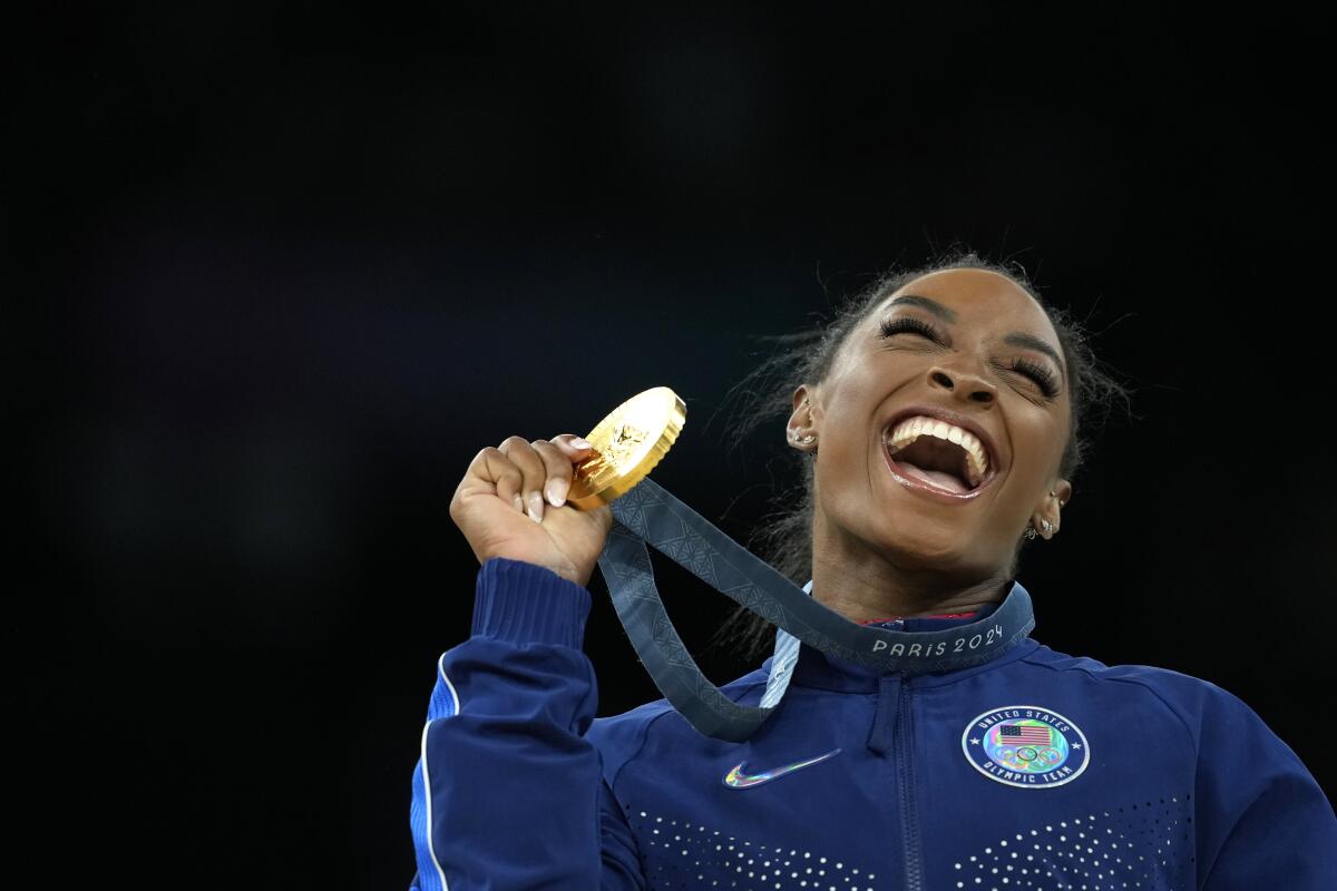 Simone Biles, of the United States, celebrates with the gold medal after winning the individual vault finals 