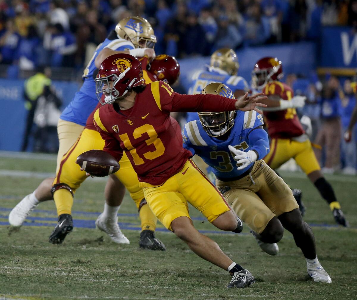 USC quarterback Caleb Williams avoids the rush of UCLA linebacker Carl Jones Jr.