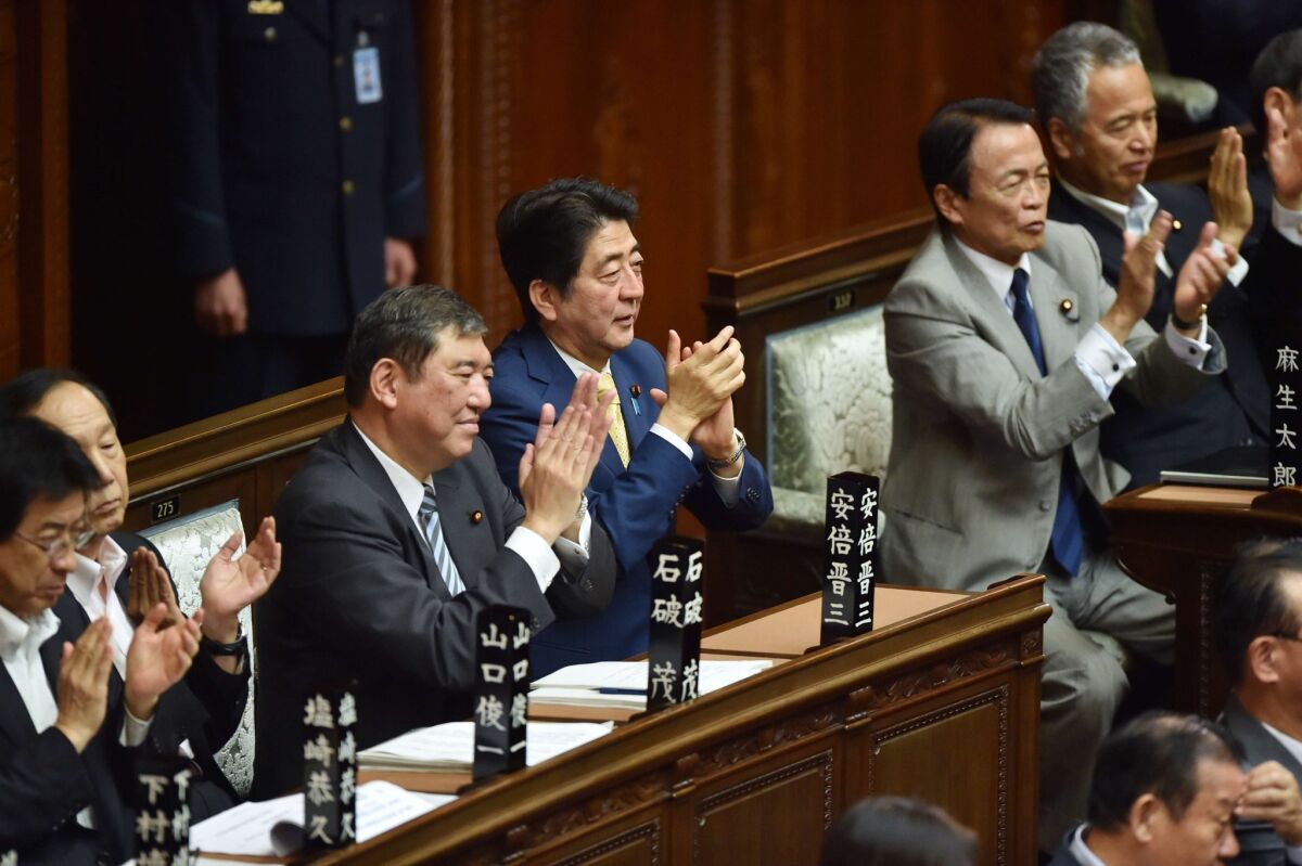 Japan's Prime Minister Shinzo Abe, center, with members of his Cabinet at a lower house plenary session July 16 at parliament in Tokyo. Security bills were approved to expand the nation's military role.
