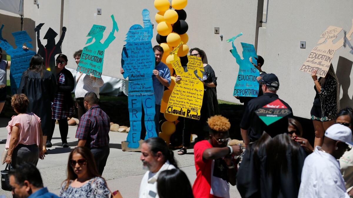 Demonstrators hold signs in support of Claudia Rueda, a Cal State L.A. student detained by Border Patrol in Boyle Heights on Thursday.