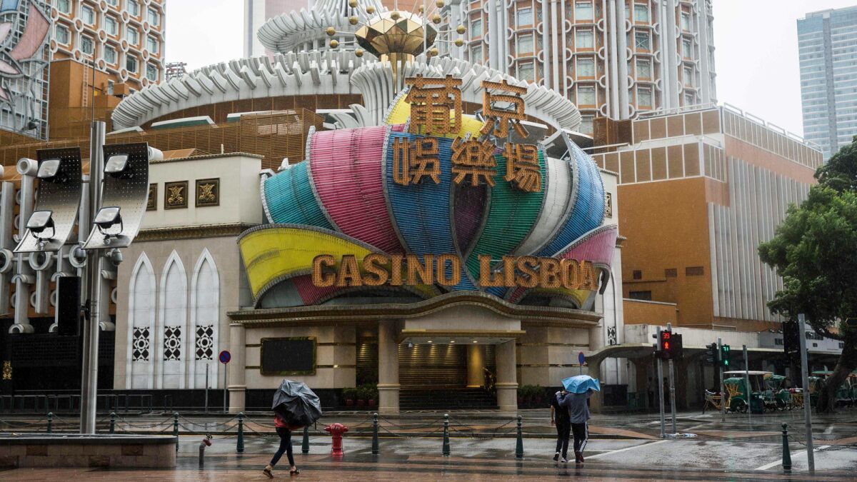 Pedestrians pass Casino Lisboa, which was closed, as Typhoon Mangkhut edged toward Macau.