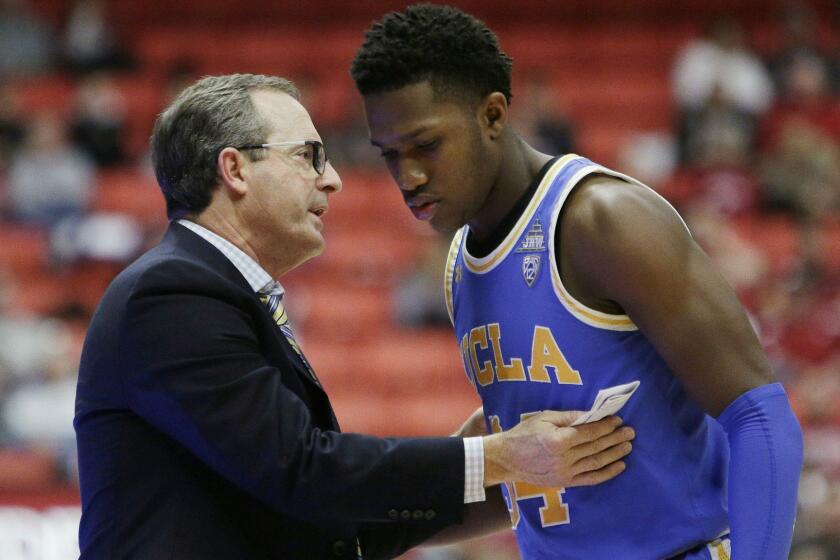 UCLA interim coach Murry Bartow, left, speaks with guard David Singleton during the second half of the team's NCAA college basketball game against Washington State in Pullman, Wash., Wednesday, Jan. 30, 2019. UCLA won 87-67. (AP Photo/Young Kwak)