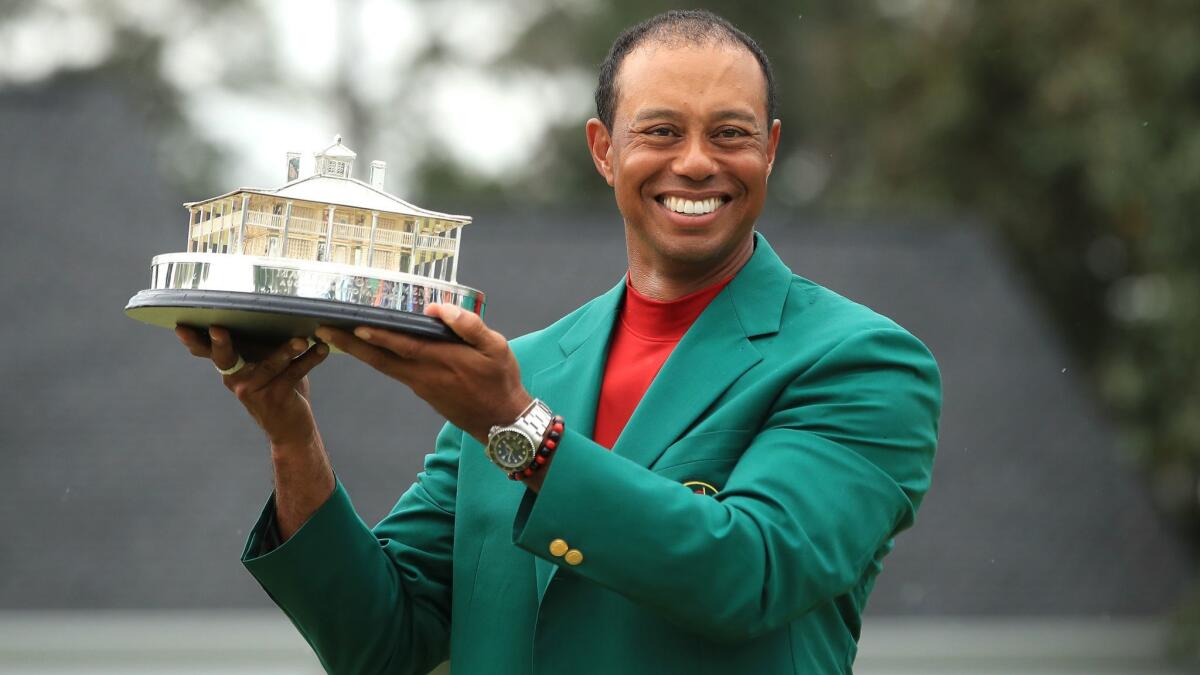 Tiger Woods celebrates with the Masters trophy after winning at Augusta National Golf Club on Sunday.
