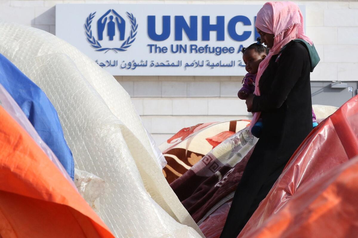 A woman from Sudan's Darfur region walks past tents during a sit-in outside the office of the United Nations High Commissioner for Refugees in Amman, Jordan, in December.