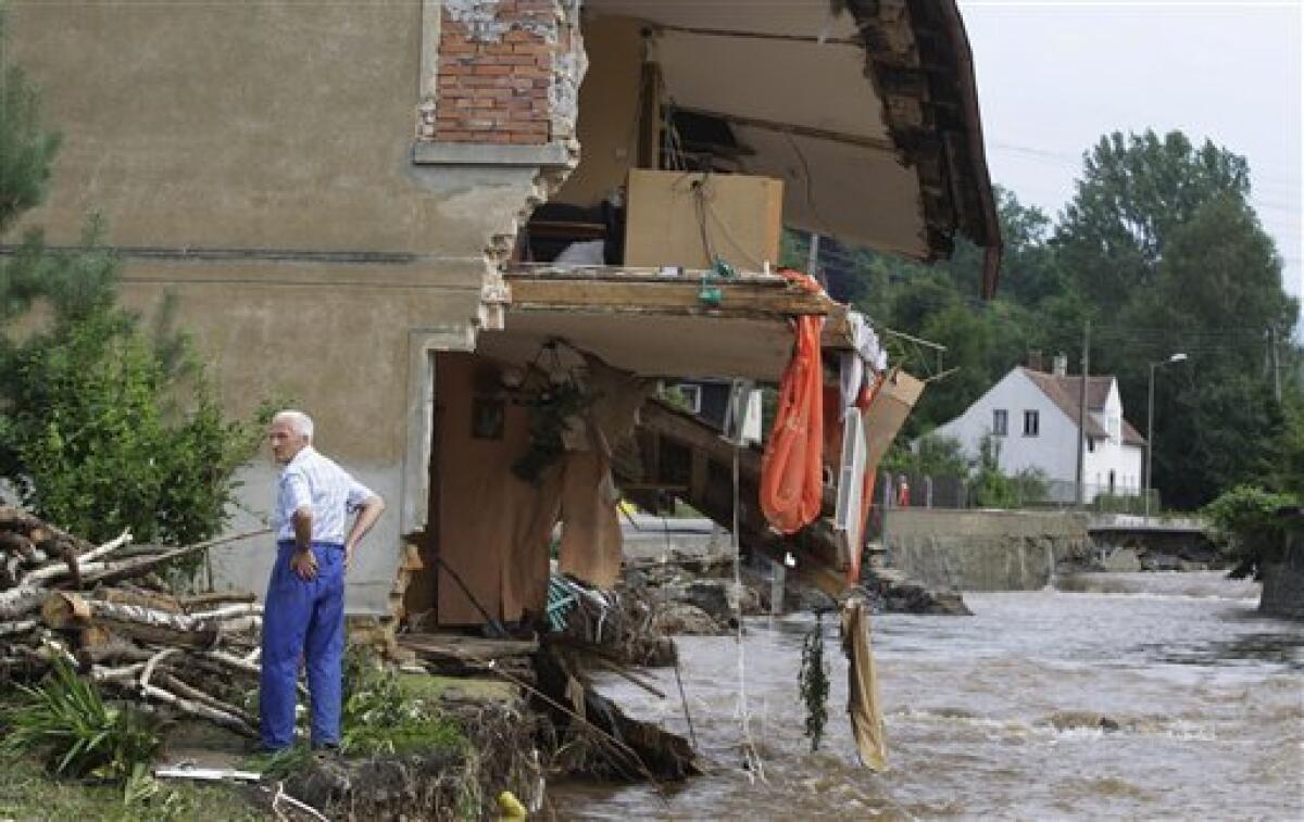 A resident stands by his destroyed house after flash floods in the town of Bogatynia, Poland, Sunday, Aug. 8, 2010. The flooding has struck an area near the borders with Germany and the Czech Republic, where there have also been several fatalities. (AP Photo/Petr David Josek)
