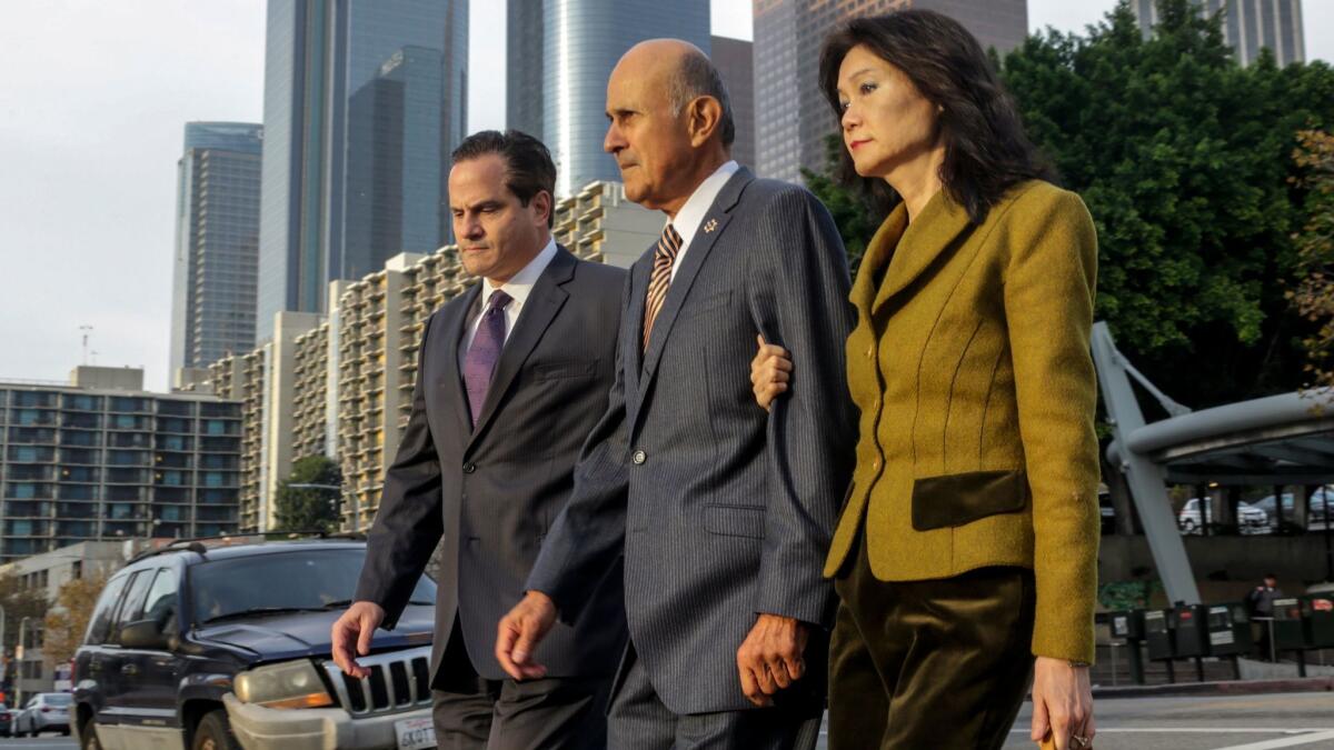 Former Los Angeles County Sheriff Lee Baca, center, flanked by his attorney Nathan J. Hochman, left, and wife Carol Chiang, arrives at federal court.
