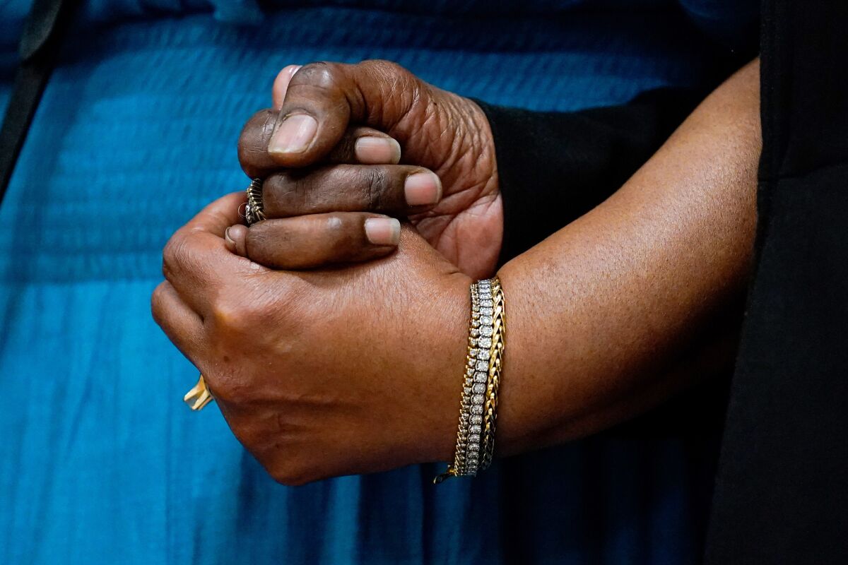 The daughters of Ruth Whitfield, a victim of shooting at a supermarket, Angela Crawley, left, and Robin Harris, hold hands during a news conference in Buffalo, N.Y., Monday, May 16, 2022. (AP Photo/Matt Rourke)