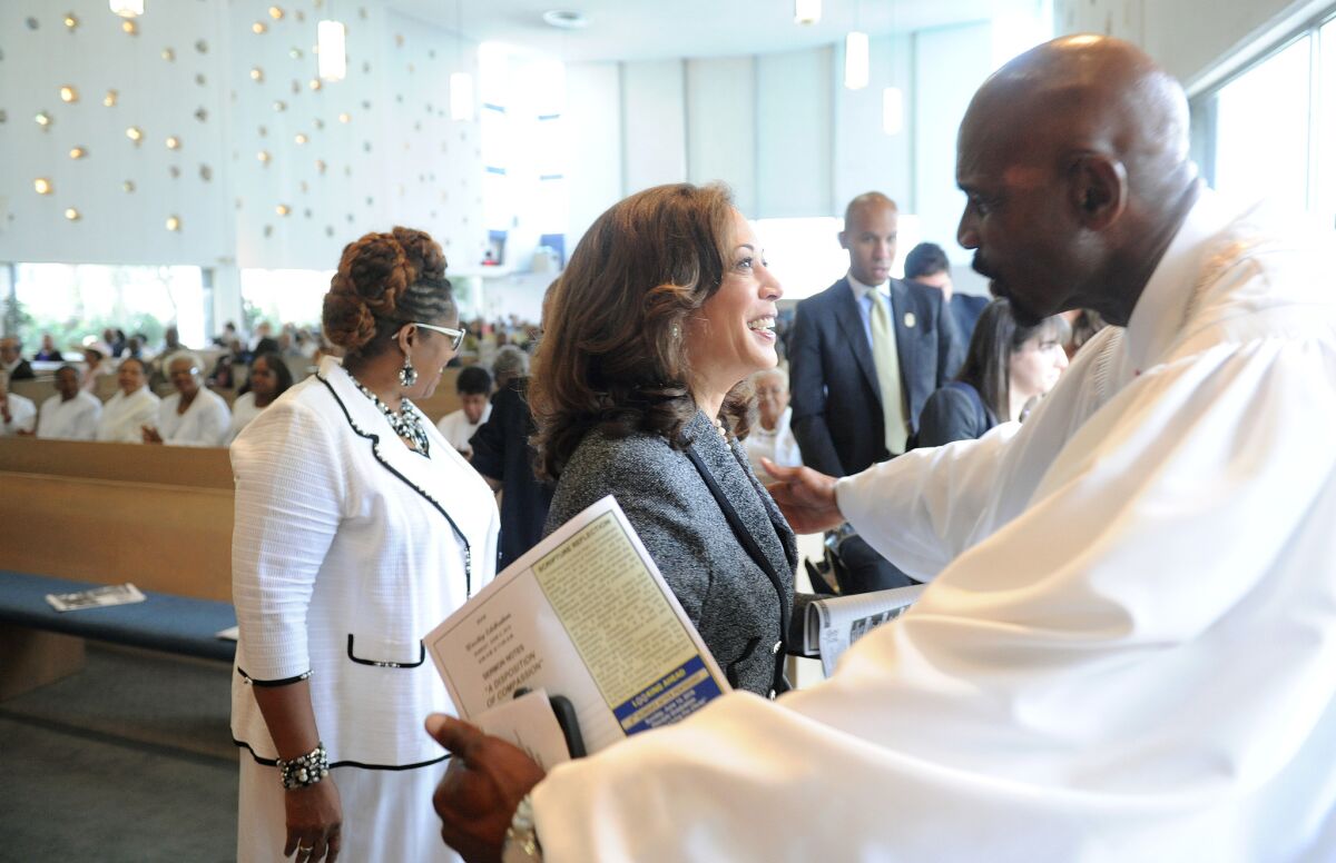 The Rev. Oliver Buie of Holman United Methodist Church in Los Angeles, right, thanks U.S. Senate candidate Kamala Harris for attending a church service Sunday.