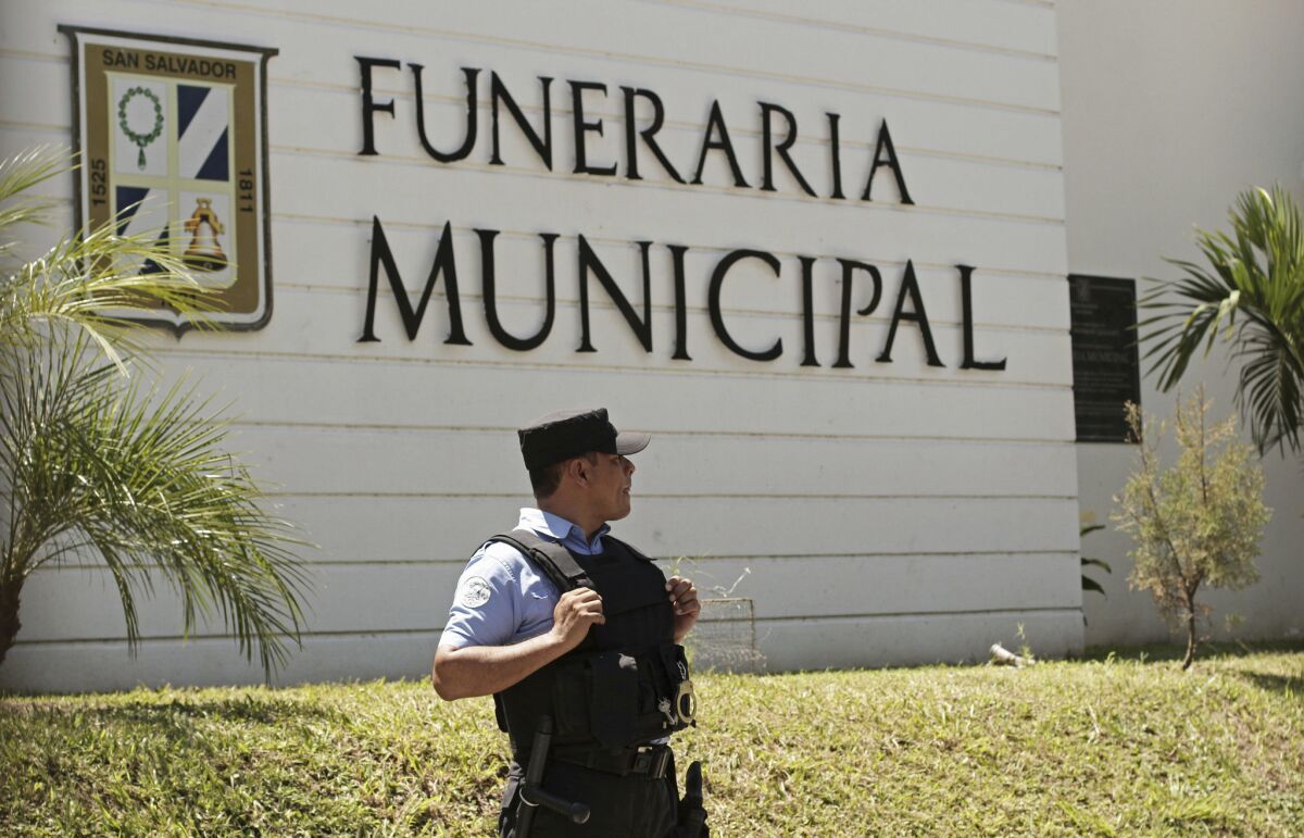 A police officer stands outside the municipal funeral home at La Bermeja cemetery, where the bodies of Oscar Alberto Martinez Ramirez, 25, and daughter Angie Valeria, nearly 2, arrived in San Salvador.