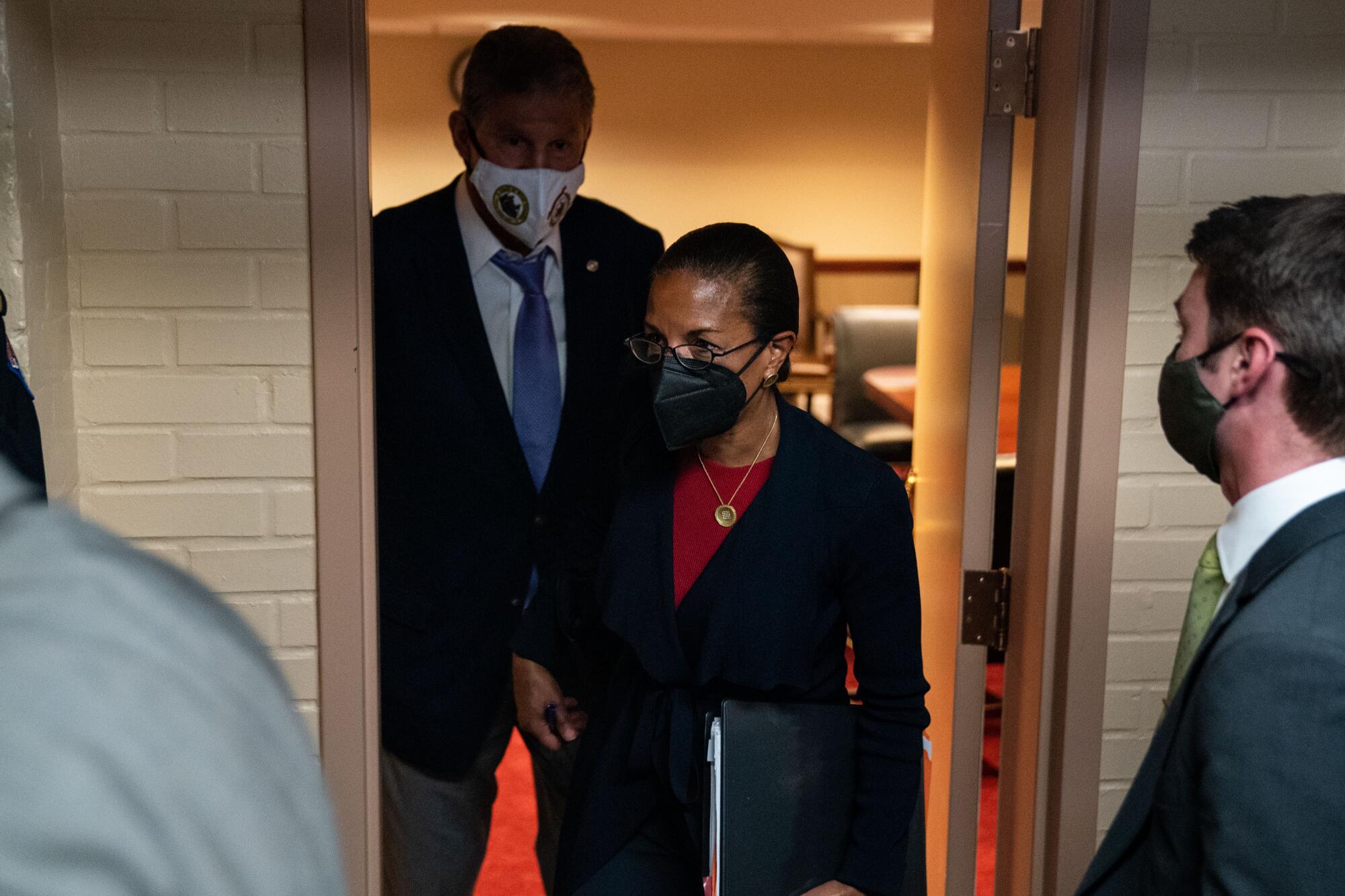 Joe Manchin and Susan Rice appear in a doorway