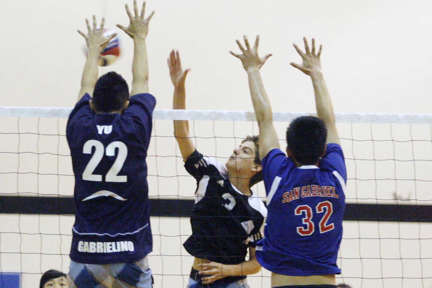 St. Francis' Charles McCarthy, center, spikes the ball during a volleyball match against public schools, which took place at Caltech in Pasadena on Saturday, June 9, 2012.